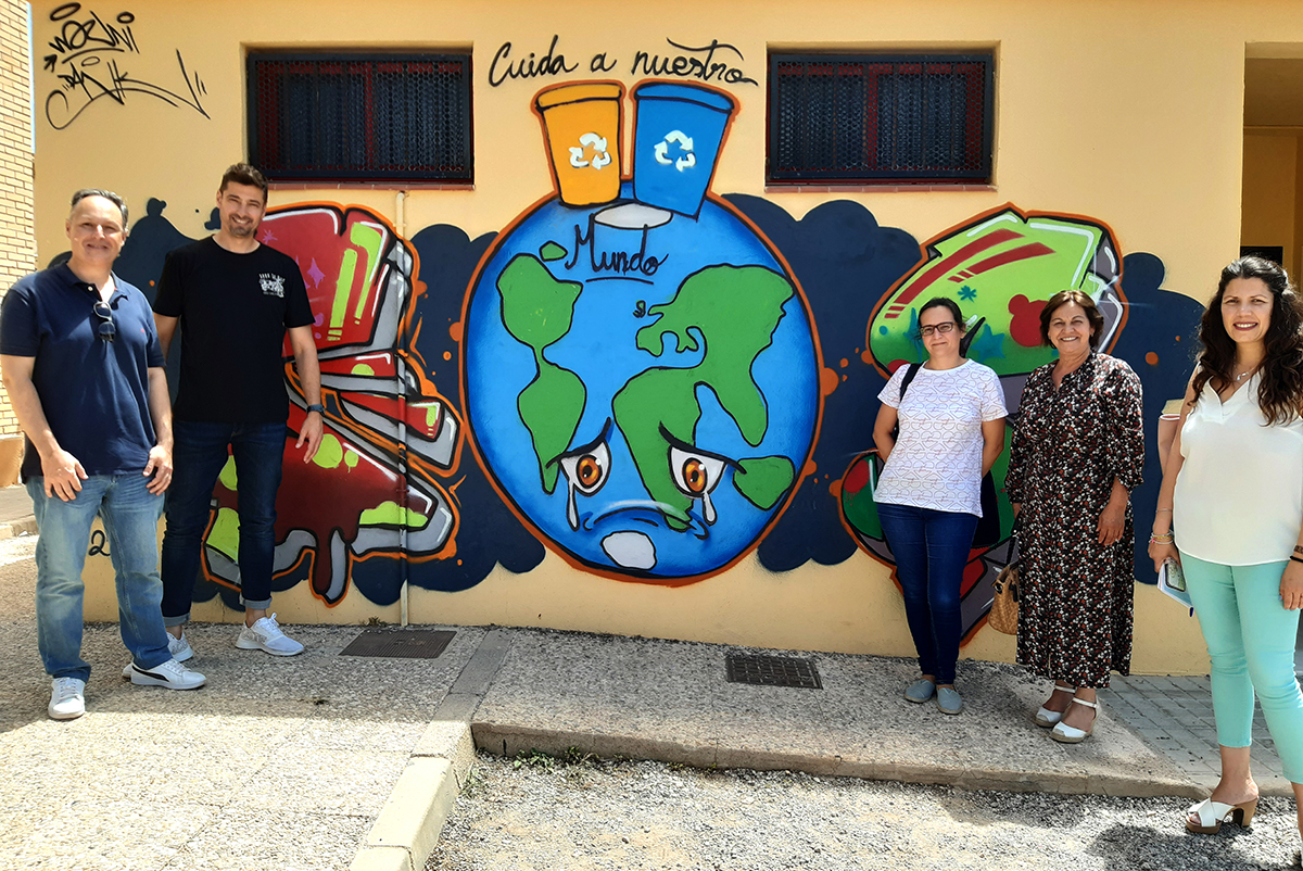 Miembros del colegio Virgen de la Paz y personal municipal y técnico frente a un grafiti del centro